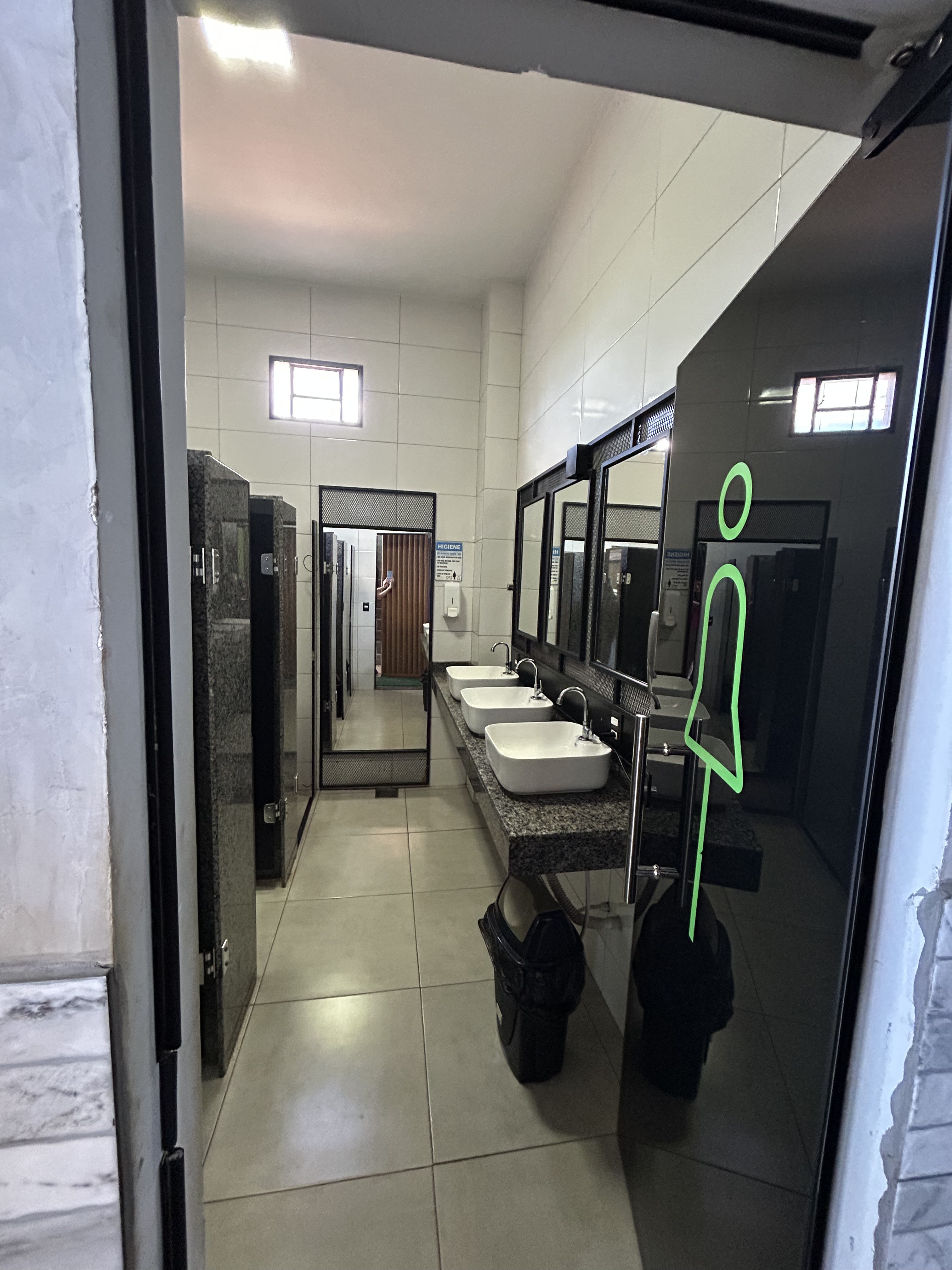 Vestiário feminino da Academia Bravus Fitness, com pias e boxes de chuveiro